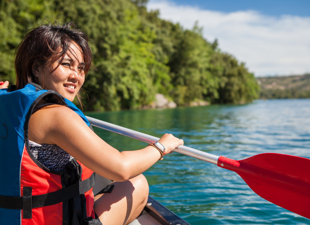 smiling woman in mycanoe folding boat on water